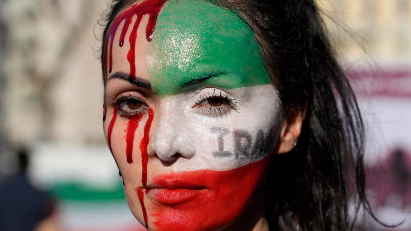 A woman in Rome paints her face during a protest against the death of Mahsa Amini, a woman who died while in police custody in Iran