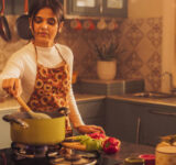 Indian Woman Cooking In Kitchen-Istock